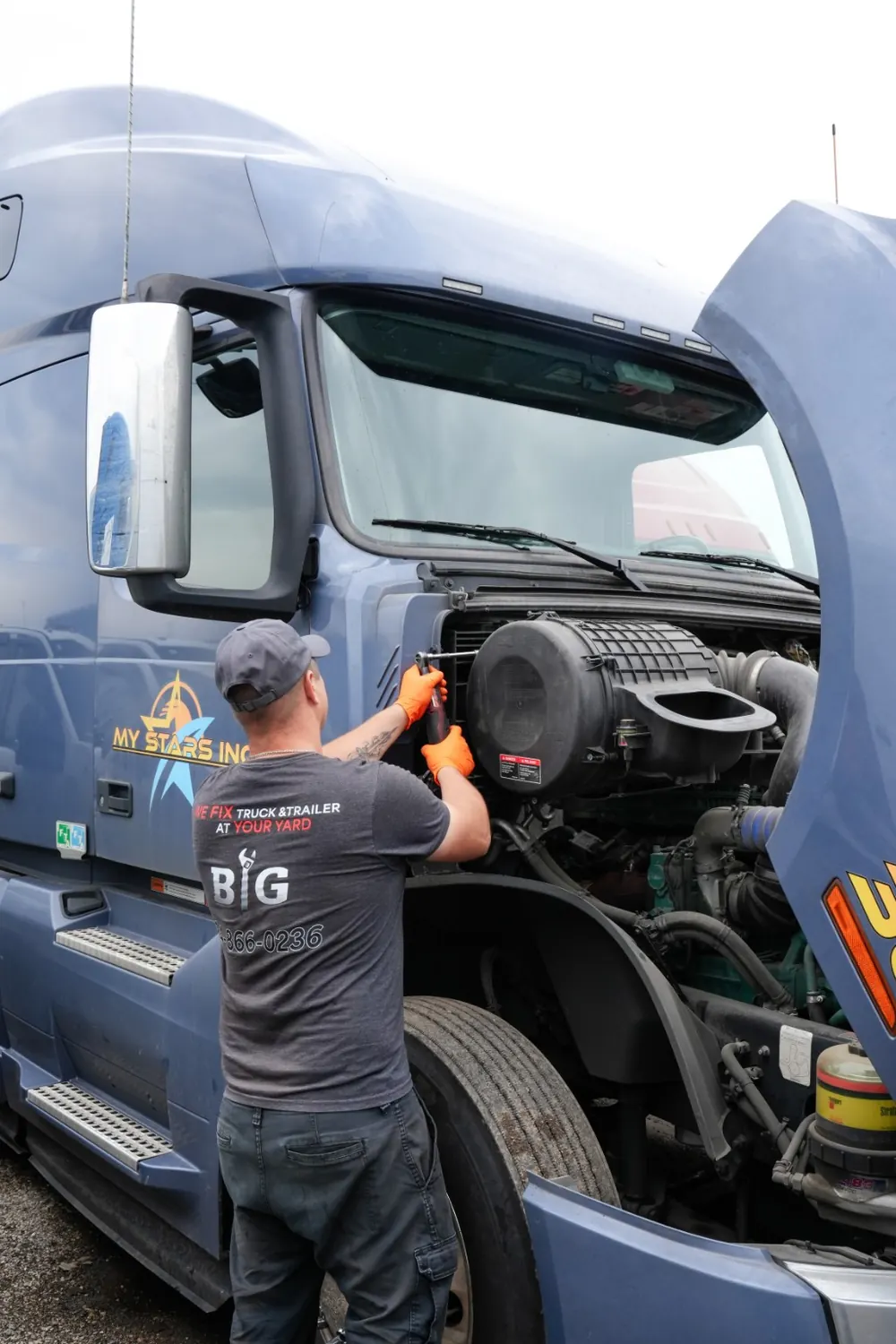 BIG mechanic repairing a semi truck engine