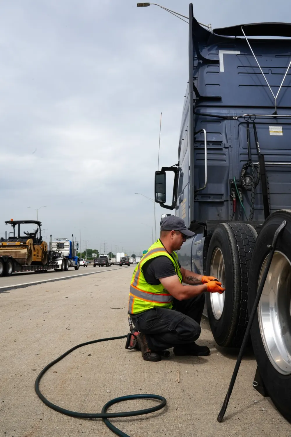 BIG mechanic servicing a truck wheel on the roadside